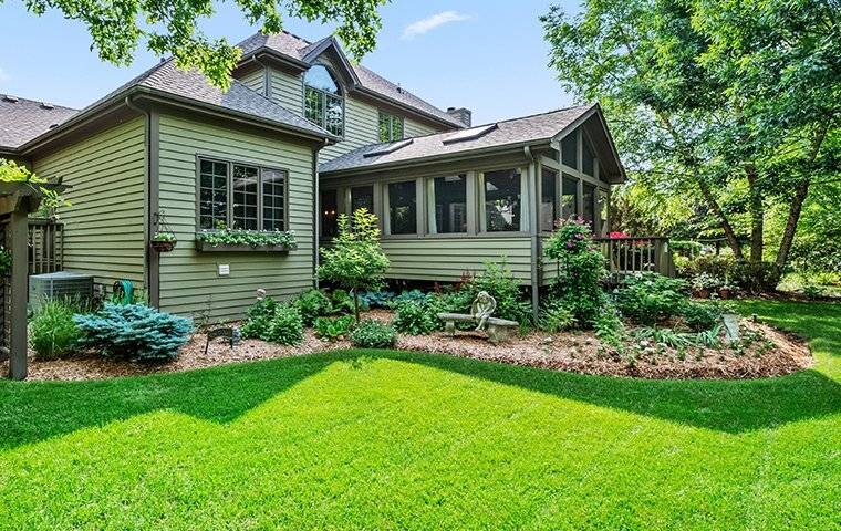 A Southlake, TX home with green grass and trees in the back yard.