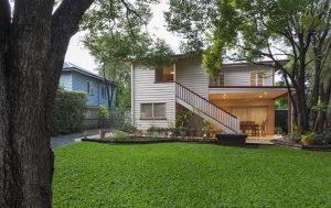 A spacious house featuring a green lawn and a beautiful staircase.