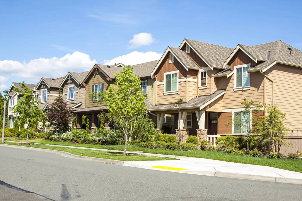 A row of suburban houses with gabled roofs lines the sidewalk, enhanced by lush trees on a sunny day, creating a picturesque community often overseen by diligent property managers. A row of suburban houses with gabled roofs lines the sidewalk, enhanced by lush trees on a sunny day, creating a picturesque community often overseen by diligent property managers.